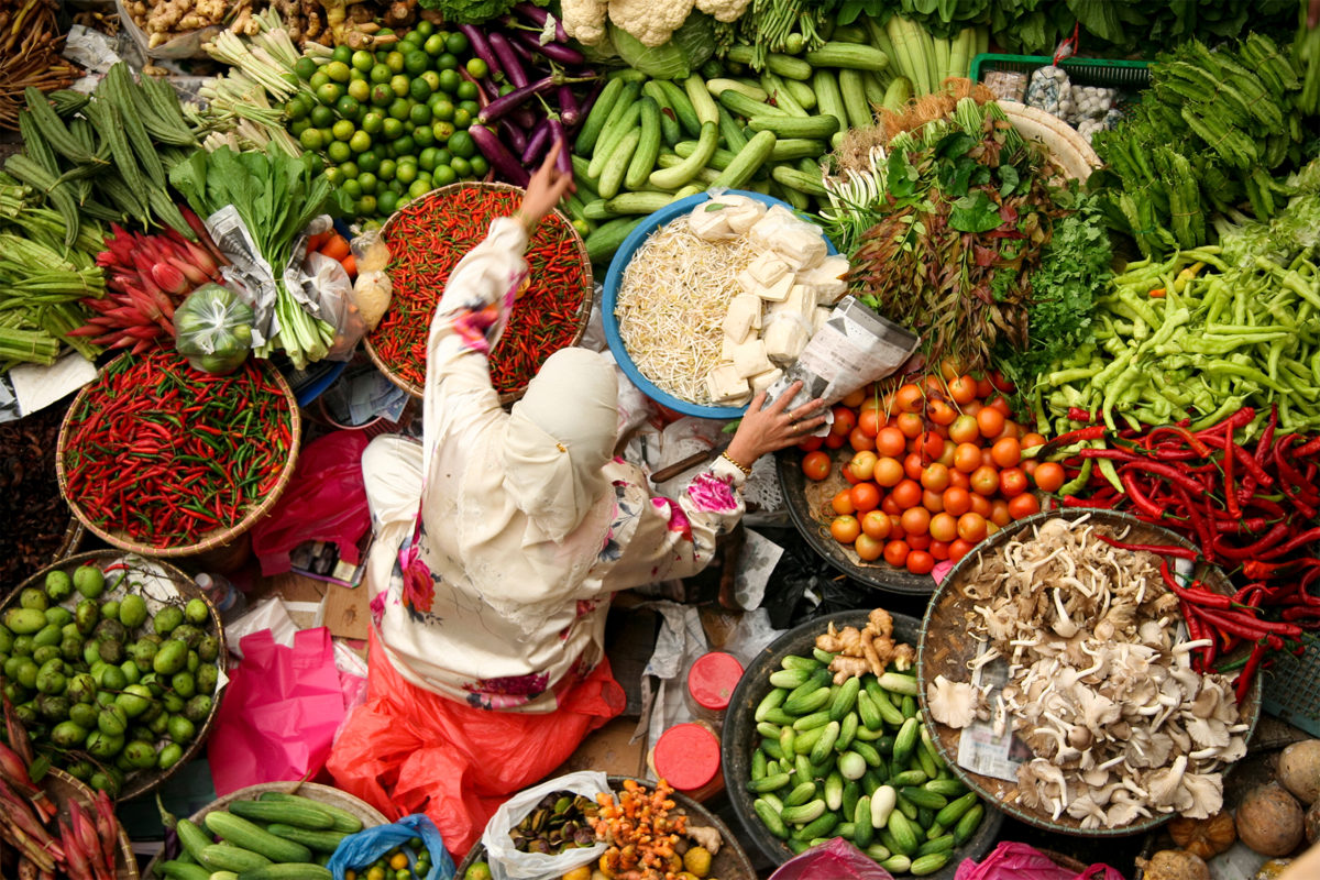Woman sitting in fresh vegetable market